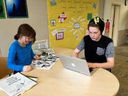 Two students working on a laptop