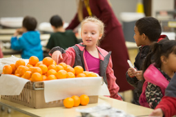  Student selecting a fresh orange.