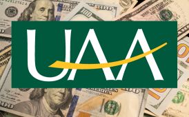  UAA logo with a background of US dollar bills
